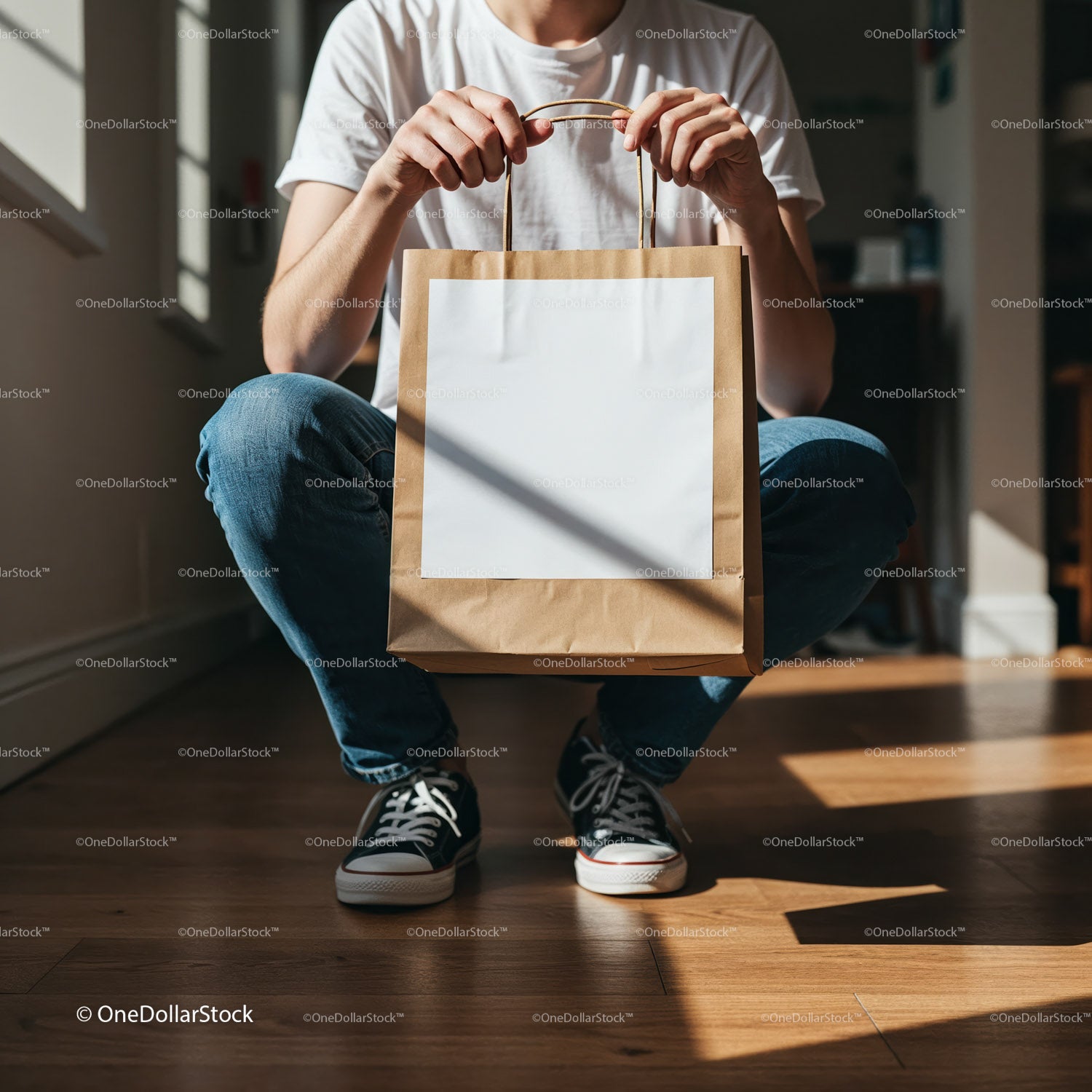 Man holding blank paper bag in casual jeans and sneakers