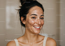 Young Woman with Freckles Smiling in Skincare Routine