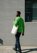 Stylish Woman in Bright Green Sweater Walking in Modern City Environment