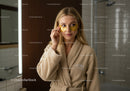 Young Woman with Golden Eye Patches in Spa Facial Treatment