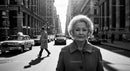 Elegant Elderly Woman Walking in Busy City Street in Black and White