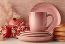 Pink Ceramic Mug and Plates with Pomegranate and Fruit on Table
