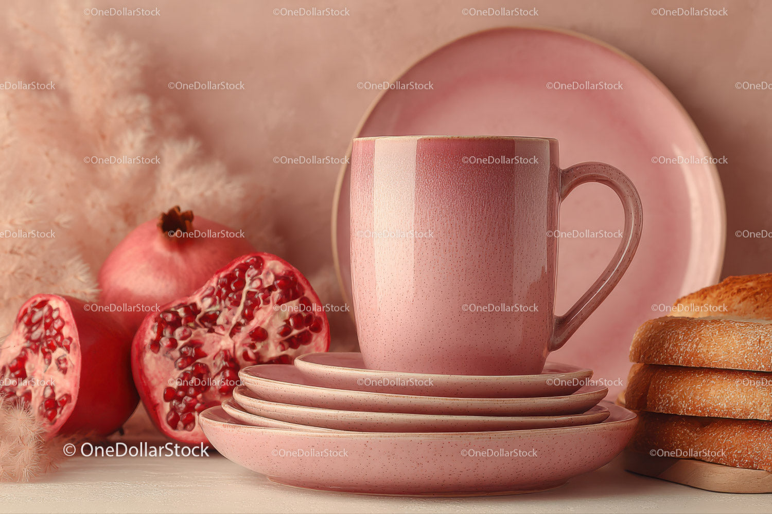 Pink Ceramic Mug and Plates with Pomegranate and Fruit on Table