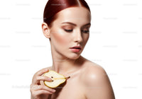 Elegant Woman with Red Hair and Pear in Hand for Beauty Concept