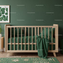 Green Baby Crib with Wooden Frame and Soft Bedding in Nursery