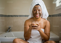 Happy Woman with Facial Mask Sitting in Bathroom Relaxing