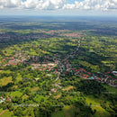 Aerial View of Lush Green Countryside and Village with Winding Road