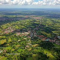 Aerial View of Lush Green Countryside and Village with Winding Road
