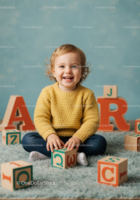 Smiling toddler playing with wooden alphabet blocks