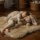 Toddler peacefully sleeping with giant plush bunny on rug