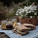 Outdoor Picnic with Fresh Baked Bread and Honey Jars in Sunlight
