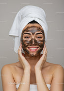 Young Woman Applying Facial Mask for Skin Rejuvenation and Relaxation