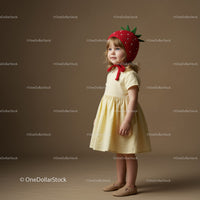 Toddler girl wearing strawberry hat and yellow dress
