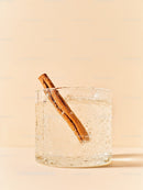 Refreshing clear drink with cinnamon stick in glass