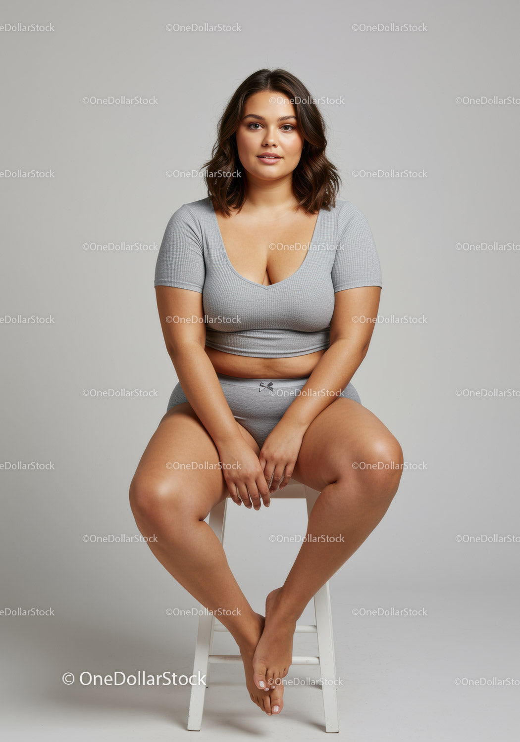 Confident Plus Size Woman Sitting on Stool in Casual Grey Outfit