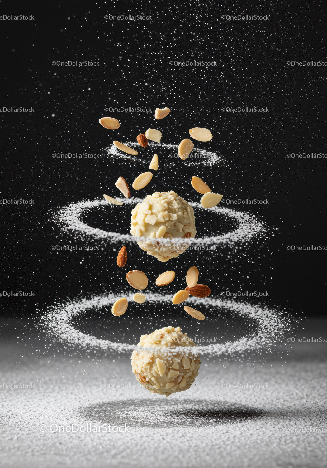 Almond truffles surrounded by swirling powdered sugar