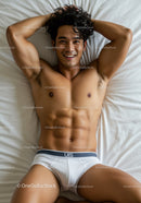 Smiling muscular man relaxing on bed in white briefs