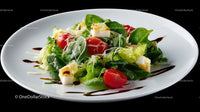 Fresh Green Salad with Cherry Tomatoes and Mozzarella on White Plate