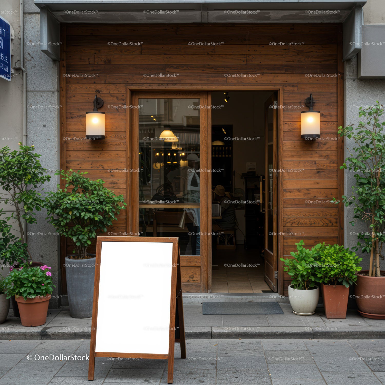 Minimalist cafe entrance with wooden signboard and plants