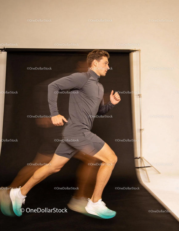 Young man running swiftly against black studio backdrop