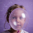 Curious child looking through a large translucent balloon