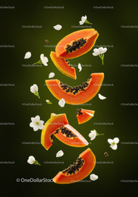 Fresh papaya slices with white flowers floating on green