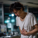 Man Experiencing Abdominal Pain in Indoor Nighttime Setting