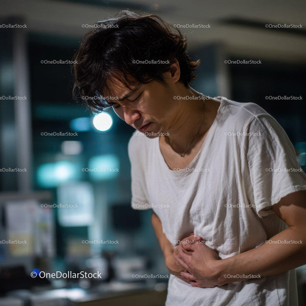 Man Experiencing Abdominal Pain in Indoor Nighttime Setting