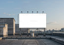 Blank billboard on urban rooftop under clear sky