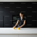 Young woman arranging lemons on modern white kitchen island