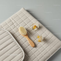 Natural baby grooming essentials on quilted changing mat