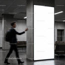 Blurred man walking past illuminated urban advertisement panel