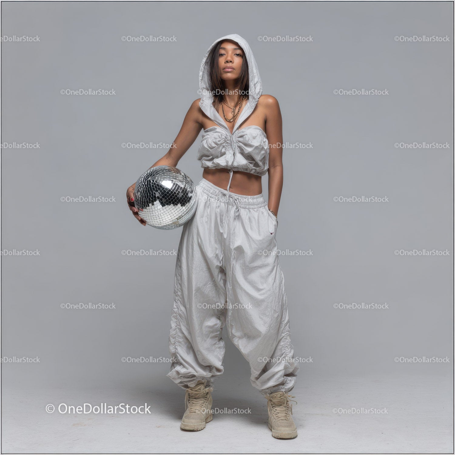 Stylish Woman in Metallic Outfit Holding Disco Ball for Modern Fashion