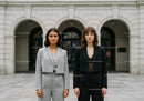 Fashionable Businesswomen in Elegant Suits Stand in City Street
