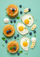 Delicious breakfast with pancakes fried eggs and fruit