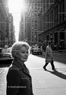 Elderly Woman in Busy City Street Surrounded by Vintage Cars