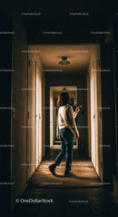 Person exploring dimly lit corridor with glowing light