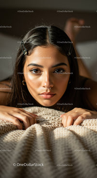 Portrait of Young Woman Relaxing on Cozy Beige Blanket in Warm Lighting