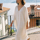 Woman in Flowing White Dress by Lakeside Balcony