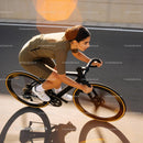 Focused female cyclist racing on smooth track