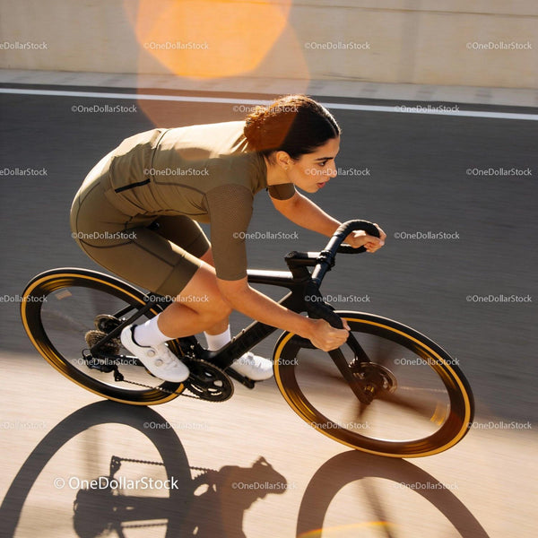 Focused female cyclist racing on smooth track