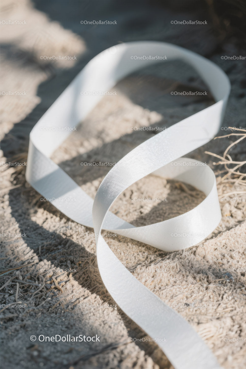 Close-up of White Plastic Ribbon Waste on Sandy Beach