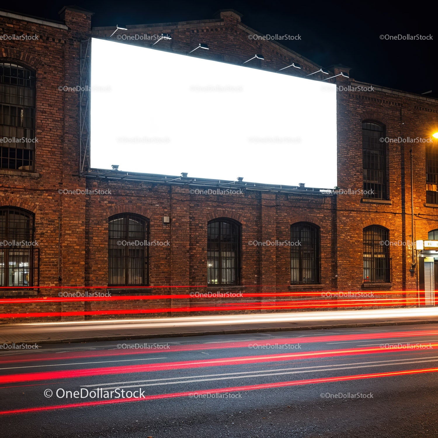Pusty, oświetlony billboard na zabytkowym ceglanym budynku w nocy