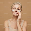 Elegant Mature Woman Applying Skincare Cream on Cheek