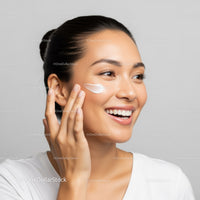 Young Woman Applying Skincare Cream with Bright, Flawless Skin