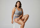 Young Woman in Casual Gray Sportswear Sitting on a White Stool
