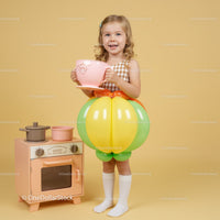 Little girl in balloon skirt holding giant teacup