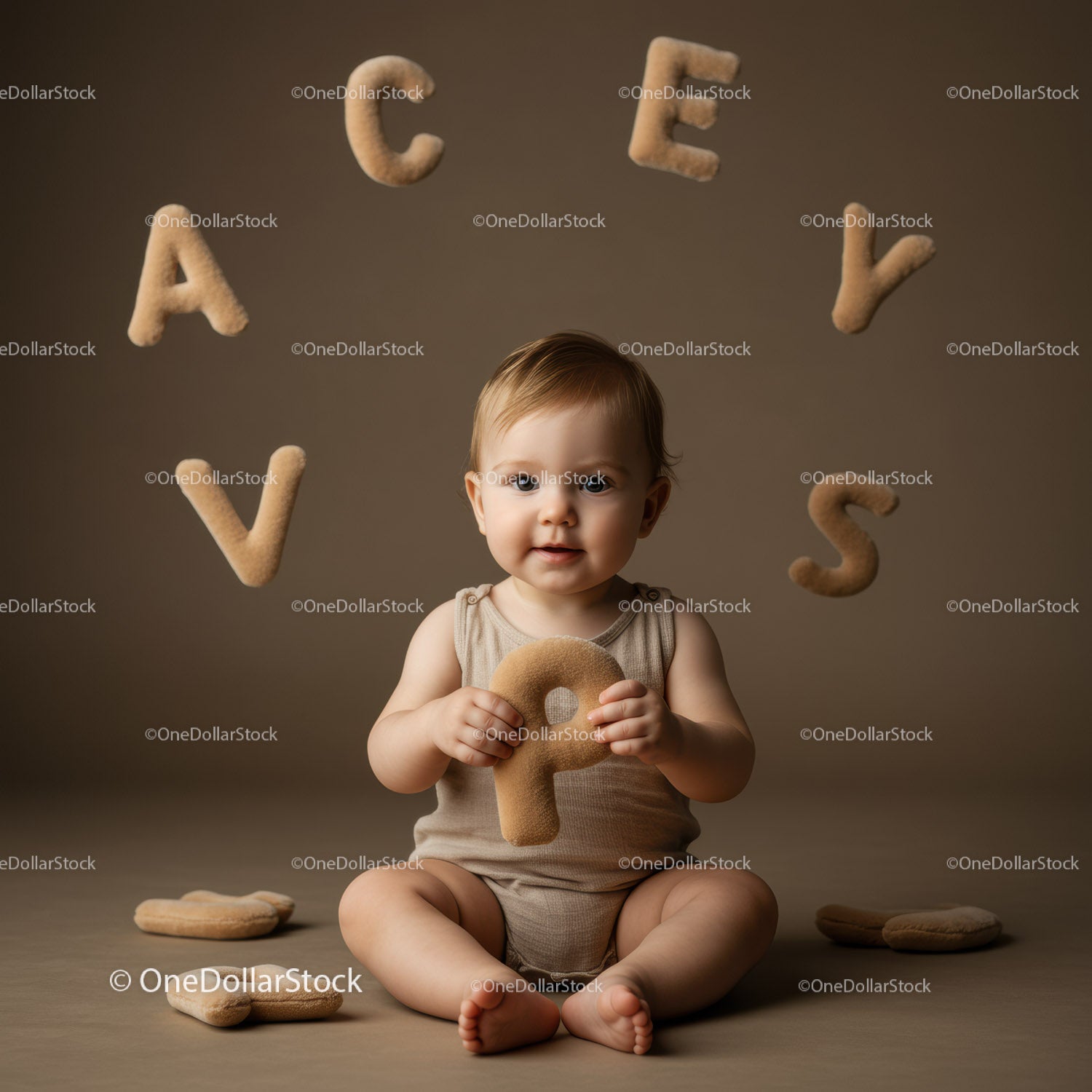 Adorable baby holding soft alphabet letter indoors