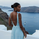 Woman in elegant blue dress overlooking sea cliffs
