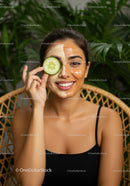 Young Woman with Facial Mask and Cucumber in a Wellness Setting